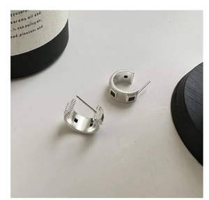 Detailed macro view of S925 sterling silver earrings with black square stones and matte finish