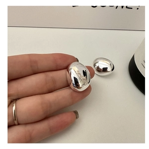 Detailed view of large oval S925 sterling silver earrings with mirror polished finish