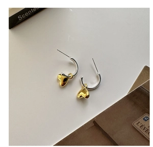 Vista macro di orecchini a cerchio in argento S925 con pendenti a cuore in oro lucido