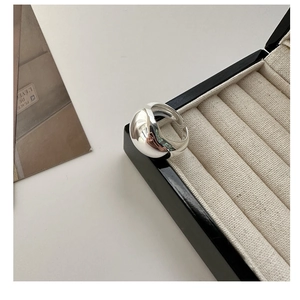 Close-up of a chunky S925 sterling silver minimalist ring on a beige velvet jewelry box