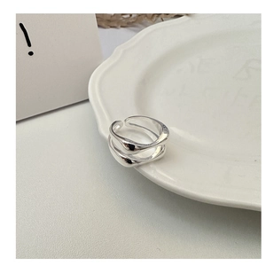 Detailed view of S925 sterling silver double-layer wave ring on a vintage ceramic plate
