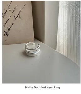 Gros plan sur une bague double couche en argent S925 mat au design minimaliste épuré