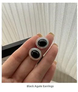 Detailed macro view of S925 silver black agate oval earrings with retro textured finish