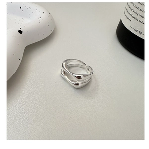 Detail of minimalist silver double-layer open ring with organic streamlined design
