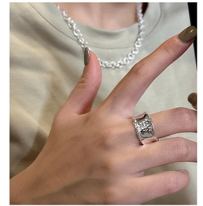 Macro detail of silver wide ring featuring textured surface and DREAM engraving