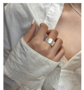 Macro detail of overlapping round matte S925 silver discs on a minimalist ring