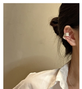 Détail d'une manchette d'oreille argentée minimaliste avec un large design incurvé