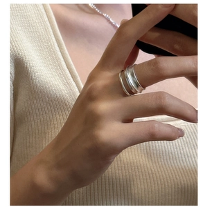 Détail d'un ensemble de bagues doubles minimalistes en argent mat sur un mannequin