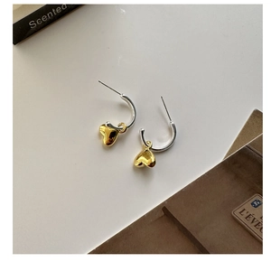 Dettaglio di orecchini a cuore in argento S925 con moderno design bicolore oro e argento