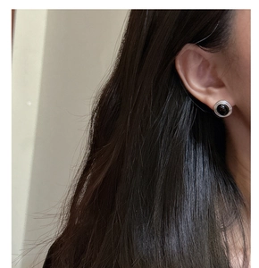 Close-up of vintage S925 silver stud earring with black onyx and spiral texture