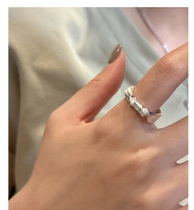 Close-up of a knotted matte S925 sterling silver ring showing minimalist geometric texture