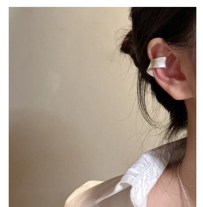 Détail d'une bague d'oreille mate en argent 925 avec une surface incurvée irrégulière