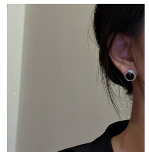 Close-up of vintage S925 silver stud earring featuring oval black onyx on a model
