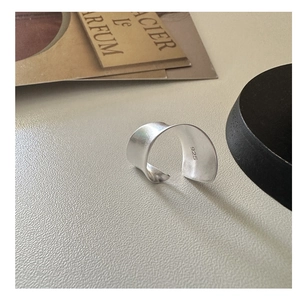 Détail macro d'une bague en argent sterling S925 avec finition mate et design vague