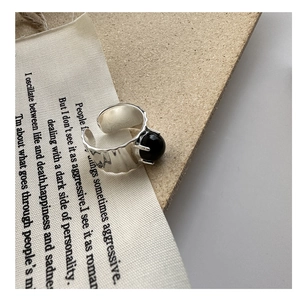 Dettaglio dell'anello regolabile in argento con onice nera e finitura martellata