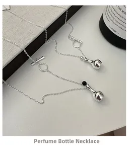 Detailed shot of S925 silver perfume bottle pendants with OT buckle on textured surface