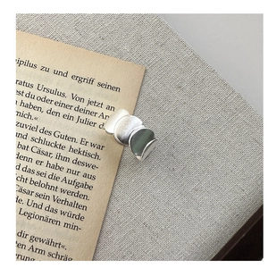 Close-up of matte S925 sterling silver wavy layered ring on a vintage book page