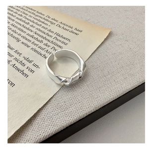 Detail of adjustable S925 silver knotted matte ring on vintage book and linen