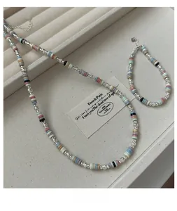 Detail view of s925 silver beaded necklace set with colorful discs on jewelry tray