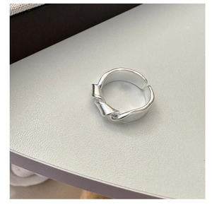 Macro shot of matte S925 sterling silver knotted ring with adjustable open band design