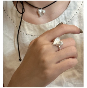 Dettaglio del set anello e collana a cuore in argento S925 con texture martellata
