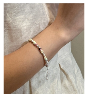 Detailed shot of multi-color beaded bracelet with silver metal clasp on a model wrist