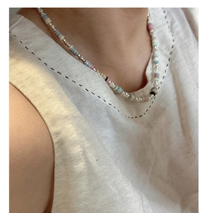 Detail of s925 silver necklace featuring colorful clay beads and metallic spacers on model