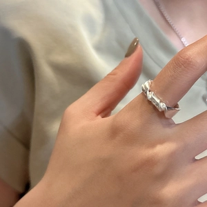 Minimalist S925 sterling silver knotted ring with a twisted geometric design on model's finger