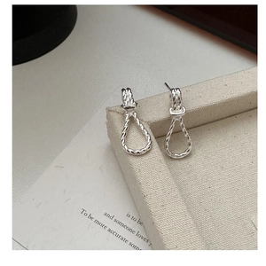 Detailaufnahme der S925 Silber Knot Ohrringe mit gedrehter Textur auf einer Schmuckschatulle