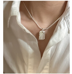 Detailed view of S925 sterling silver rectangular pendant engraved with Live in the moment