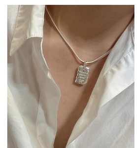 Close-up of S925 sterling silver necklace with textured pendant and inspirational engraving