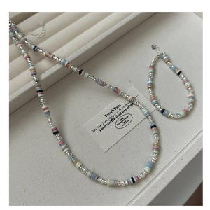 Detail view of colorful Heishi beads jewelry set including necklace and bracelet in display tray