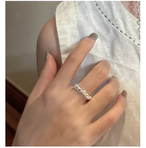 Close-up of a sterling silver twisted croissant ring worn on a finger for a minimalist look