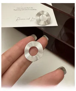 Vue détaillée des boucles d'oreilles en argent S925 avec motif plissé circulaire