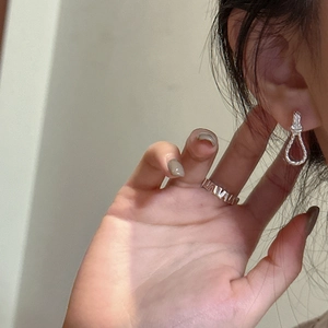 Minimalistische S925 Silber Knotohrringe und hohler geometrischer Ring am weiblichen Model