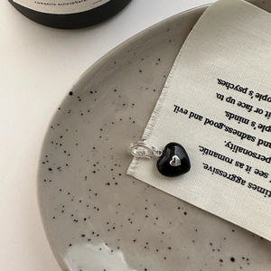 Minimalist S925 sterling silver heart necklace with black enamel pendant on ceramic tray