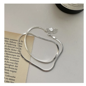 Detail of silver flat snake bone chain with lobster clasp and square brand tag