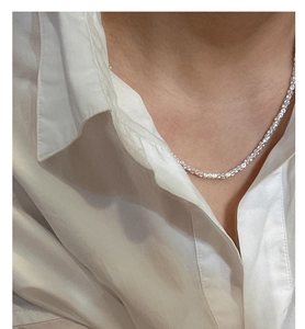 Detail of S925 sterling silver square stone necklace on a white shirt collar