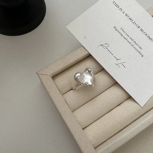 Anello cuore in argento S925 con trama fusa su un elegante espositore per gioielli