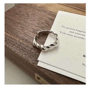 Macro detail of silver S925 sterling silver twisted croissant ring with glossy texture