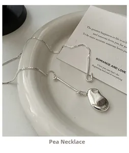 Macro detail of S925 sterling silver bean pendant with authentic S925 hallmark engraving