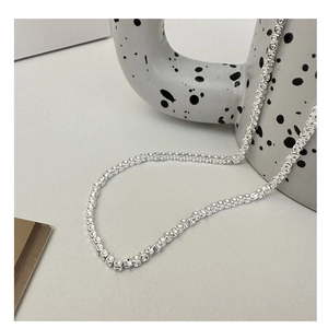 Close-up of S925 sterling silver square bead chain necklace on white ceramic surface
