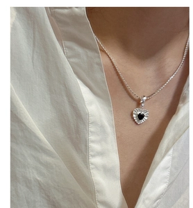 Detail view of S925 silver necklace with black heart zircon and radial texture