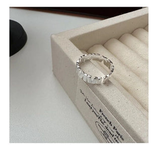 Detailed view of S925 sterling silver ring with vertical texture on canvas jewelry display