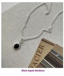 Macro shot of S925 silver necklace with black agate stone and intricate floral patterns