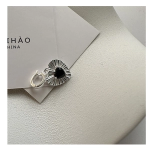 Macro detail of S925 silver heart pendant with black zircon and textured radial finish
