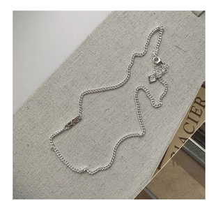 Detailed macro view of S925 silver necklace with engraved texture and logo tag