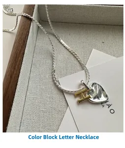 Detail of S925 silver necklace featuring a gold letter H and silver textured heart pendant