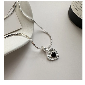 Macro shot of S925 sterling silver twisted chain and black zircon heart pendant detail