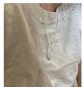 Close-up of minimalist S925 sterling silver irregular bean necklace on neck